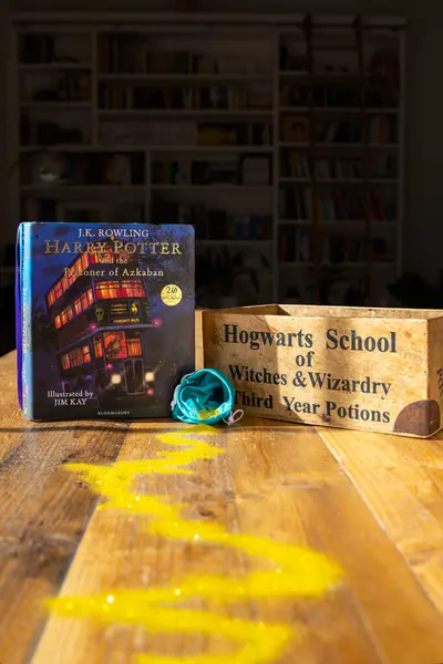Torbryan, Devon, İngiltere. 10-26-24. Azkaban 'ın esiri. Harry Potter. Atmosferik resim, karanlık bir kitaplığın arka planında geçen büyülü altın çizgisi..