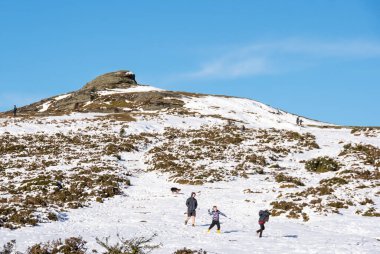 Haytor, Devon, uk. 01-07-25. A snowball fight at Haytor rock on Dartmoor in England. Snowy winter Panoramic picture showing the granite landmark taken in the Dartmoor National park.Family fun. clipart