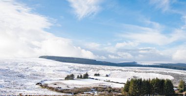 Dartmoor Ulusal Parkı karlı panoramik görüntüsü. Yuvarlanan beyaz kırsal ve mavi gökyüzü ile güzel kış manzarası. 