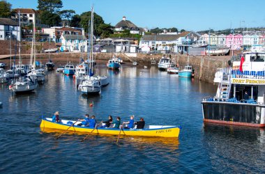 Paignton, Devon, İngiltere. 09-18-24. Bir yarışçı gemisi Paignton Limanı 'ndan ayrılıyor. Mürettebat kürek çekmeye devam ediyor.. 