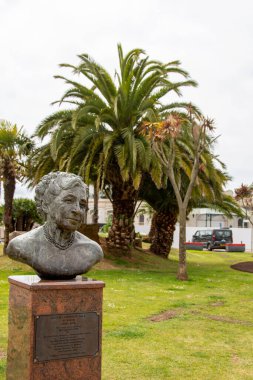 Torquay, Devon, uk. 06-11-25. Agatha Christie 'nin Torquay, Devon' daki büstü. Torquay 'ın ünlü palmiye ağaçları arka planda oturur..