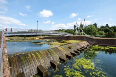Exeter, Devon, İngiltere. 08-06-25. Millerlar Exe nehrinin üzerinden Exeter 'e geçiyorlar. Büyük değirmen taşları köprünün yapısını destekliyor.