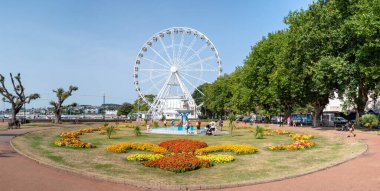 Torquay, Devon, uk. 08-15-25. Torquay genelinde panoramik resim, fıskiyenin arka planında parlak yaz çiçekleriyle Prenses bahçeleri, büyük tekerlek ve Prenses tiyatrosunu gösteriyor. İngiliz Rivierası