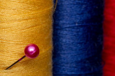 Dikiş ipliğinin çok renkli makaraları yığını