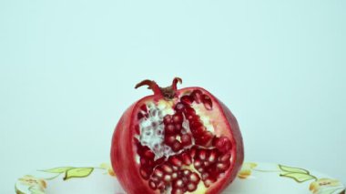 Kırmızı nar ve nar taneleri beyaz bir arka plan üzerinde