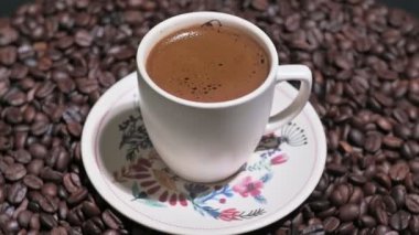 Kahve fincanı, kavrulmuş kahve çekirdeğinin ortasında.