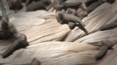 Turntable 'da kurutulmuş karanfil taneleri ve bir şişe karanfil yağı.