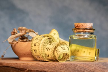Tahta arka planda taze ıhlamur çiçekleri olan bir şişe ıhlamur yağı..