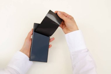 Yeni akıllı telefonları aç. Yeni bir telefondan koruyucu siyah film çıkarıyorum. Bir kadının ellerine yakın çekim. Beyaz arka plan. Akıllı telefon samsung galaksisi S23 ultra.