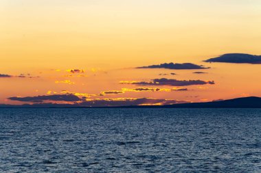 Deniz ve mavi bulutlar üzerinde turuncu gün batımı. Karşıtlık arkaplan, doku, kopyalama alanı.
