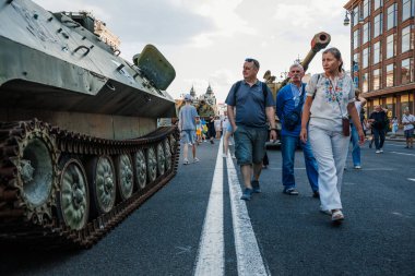 Ukrayna 'nın Bağımsızlık Günü kutlamaları sırasında yıkılmış Rus askeri araçlarının kalıntıları arasında Khreshhatyk Caddesi boyunca yürüyen insanlar