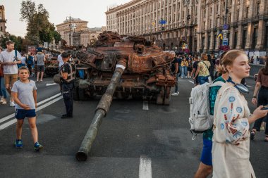 Ukrayna 'nın Bağımsızlık Günü kutlamaları sırasında yıkılmış Rus askeri araçlarının kalıntıları arasında Khreshhatyk Caddesi boyunca yürüyen insanlar