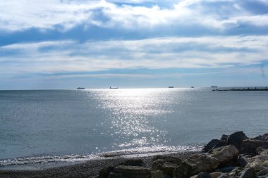 Akdeniz okyanusu beyaz bulutlarla mavi gökyüzüne eşlik ediyor.