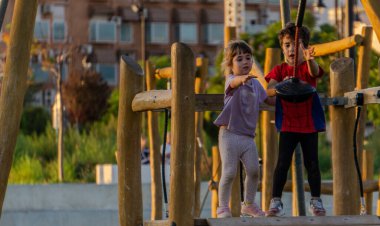 Çocuklar eğlence parkında teleferik hattıyla eğleniyor.