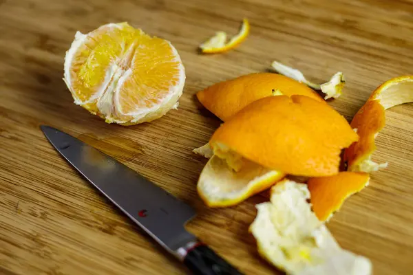 Portakal soyulmuş ve tahta kesme tahtasıyla soyulmuş ve Japon bıçağıyla kesilmiş. Yüksek kalite fotoğraf