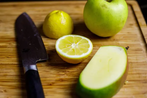 Limon, mango ve yeşil elma meyve suyu hazırlamak için tahta kesme tahtasında. Yüksek kalite fotoğraf