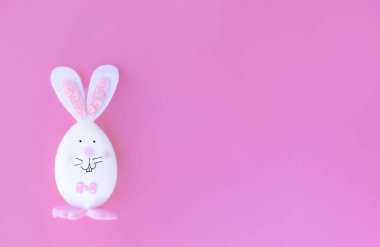 Paskalya yumurtası, pembe arka planda tavşancık şeklinde, mesaj, pankart ya da Mutlu Paskalyalar kartı için yeri var.