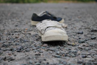 Atılmış çocuk ayakkabıları halka açık bir alanda, perspektif odaklı