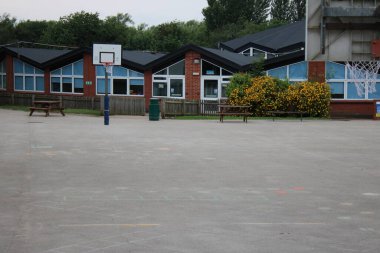 Okul bahçesinde basketbol potaları var.