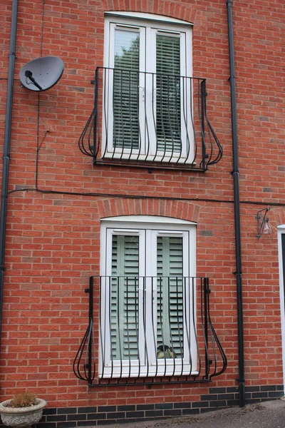 House with patio windows on first and second floor with metal grate barrier to prevent falls