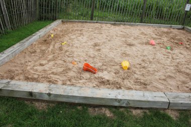 Çocuklar bulutlu bir öğleden sonra İngiltere 'de kum havuzunda toplandı.