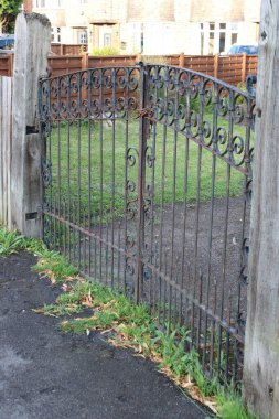 Eski dökme demir kapı zincirli ve asma kilitli.