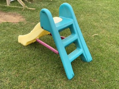 Renkli bebeklerin çimlerin üzerinde kaydığı bir resim, insan yok.