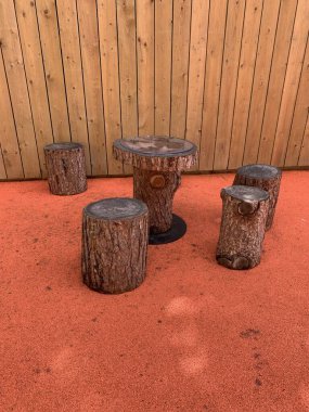 Arka planda turuncu asfalt ve çitli log koltukları ve kayıt tablosu