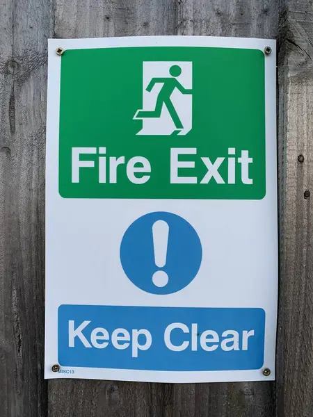 Fire Exit Keep clear sign attached to a wooden gate