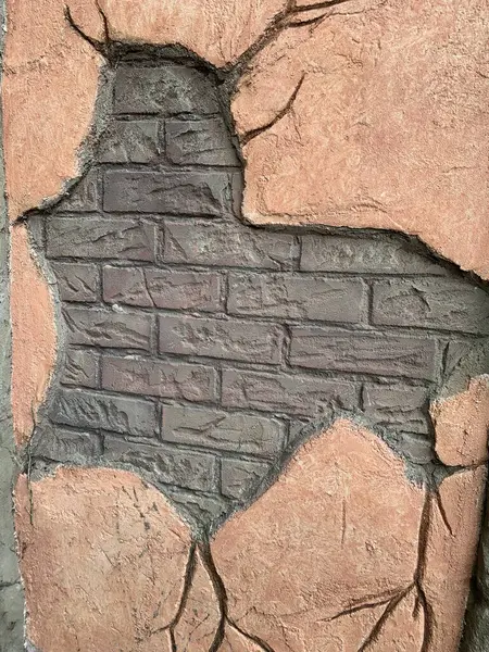 Broken render revealing brick wall underneath