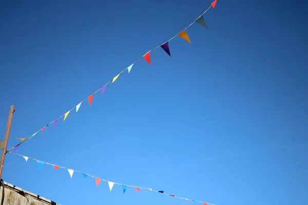 Bunting flags hanging overhead against a clear blue sky