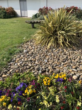 Çakıl yatağı, arka planda çalılar, dikey resim