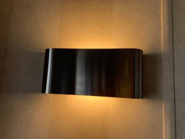 Krem rengi bir duvara bağlı modern gümüş lambanın gölgesi, aydınlık.