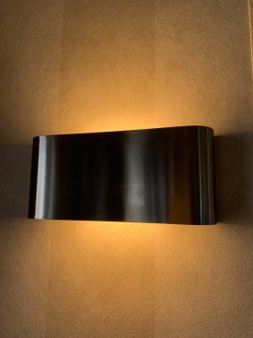 Krem rengi bir duvara bağlı modern gümüş lambanın gölgesi, aydınlık.