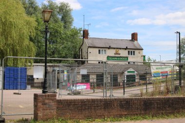 Syston, Leicestershire UK, July 5th 2024 Hope and Anchor pub closed, car park fenced off, taken from canal boat point of view clipart