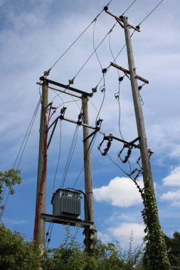 İngiliz 11KV elektrik hattı ahşap direklere basamaklı trafo aşağı iniyor.