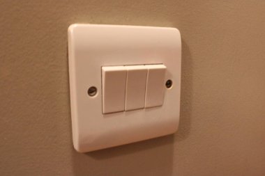 Beyaz üçlü lamba anahtarı, üç anahtar da yerine ayarlı.