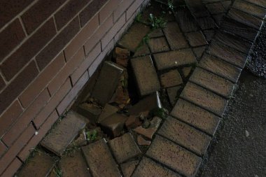 Tuğla bir yolun çökmüş bölümü, gece dışarı çıkarılmış, gizli yolculuk tehlikesi.