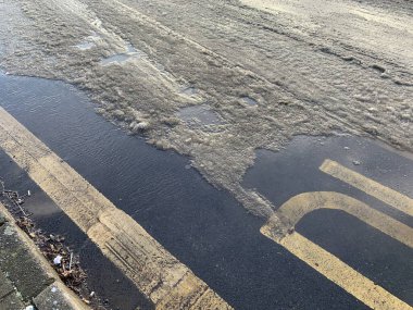 Halka açık bir yolda, gündüz çekilmiş su ve buz.