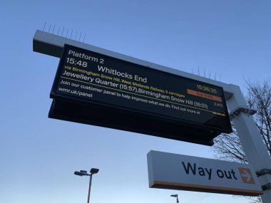 Train information board, taken outdoors, clear blue sky in background clipart