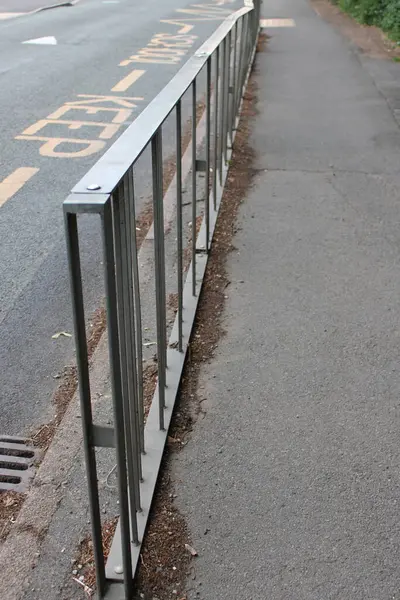 Büyük metal takviyeli korkuluklar ana yolda asfalta monte edilmiş.