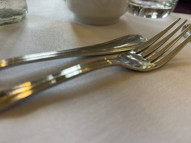 Beyaz masa örtüsü üzerinde Çatal ve Kaşık ile Akşam Yemeği