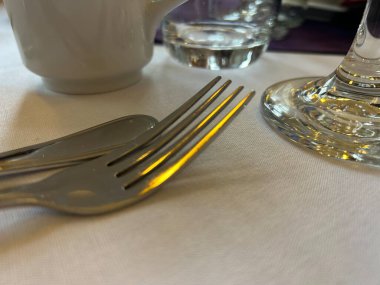 Beyaz masa örtüsü üzerinde Çatal ve Kaşık ile Akşam Yemeği