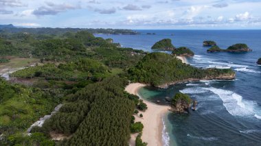 Watu Leter Plajı Tropikal Ormanı uzun kıyı şeridiyle uzaktan görülebilir.