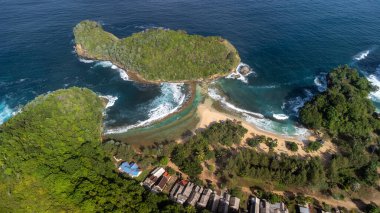 Yukarıdan görünen bir plajın, kalp gibi bir kıyı şeridine sahip olması ender rastlanan bir durum. Batu bengkung Sahili, Java Adası - Endonezya