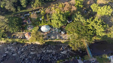 Hava görüntüsü küçük görünen bir köprü gösteriyor. Kayalık nehir çok hızlı akıyor.