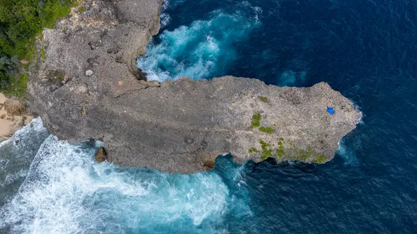 Kuş Gözü, Endonezya 'daki Watu Lepek plajının simgesi olan büyük bir kaya gösteriyor.