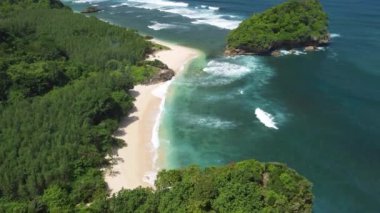 Beyaz plajın diğer tarafında Endonezya 'nın Java adasındaki tropik plaj manzarası var.