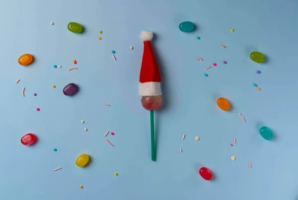 Renkli şekerler ve mavi arka planda lolipop içeren Noel kartı tasarımı