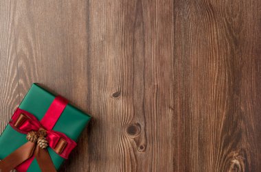 Ahşap arka planda kırmızı kurdeleli Noel hediyesi kutusu. Üst Manzara. Metin için boşluk